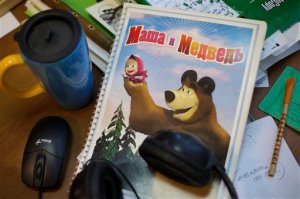 In this Wednesday, March 2, 2016 photo, a notebook with the characters of cartoon TV series Masha and the Bear lays on the desk at the company's office in Moscow, Russia. Masha and the Bear, a Russian animated television series launched in 2009, now broadcasts in more than 120 countries including the United States. Its YouTube channel is in the top 10 most-viewed worldwide. (AP Photo/Ivan Sekretarev)