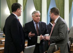 Republican Assemblymen Donald Wagner, left, Jim Patterson, center, and Devon Mathis, confer before the Assembly voted on a measure to gradually raise California's minimum wage to a nation-leading $15 an hour by 2022, Thursday, March 31, 2016, in Sacramento, Calif. Wagner and Patterson both spoke in opposition to the bill, SB3, but it was eventually approved by both houses and sent to Gov. Jerry Brown. (AP Photo/Rich Pedroncelli)