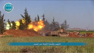 This image posted on the Twitter page of Syria's al-Qaida-linked Nusra Front on Friday, April 1, 2016, shows Nusra Front tank fires at Syrian troops and pro-government gunmen in the northern village of al-Ais in Aleppo province, Syria. The Britain-based Syrian Observatory for Human Rights says 12 Hezbollah fighters were killed and dozens were wounded in Saturday's attack by militants led by al-Qaida's Syria branch  known as the Nusra Front  on the northern village of al-Ais. The title in Arabic that reads "introduction attacks with heavy weapons on al-Ais." (Al-Nusra Front via AP)