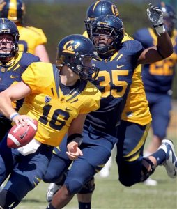 FILE - In this April 21, 2012 file photo, quarterback Allan Bridgford (16) of California's Gold team is pressured by Ted Agu (35) of California's Blue team in the first half of their California Football Spring Experience game at Edwards Stadium in Berkeley, Calif. The family of a University of California, Berkeley, football player who died after a team drill in 2014 has settled a wrongful death lawsuit with the school system for $4.75 million, officials said Thursday, April 14, 2016. The parents of 21-year-old Ted Agu sued, saying their son shouldn't have been in the strenuous workout because he carried sickle cell trait, a blood abnormality that experts believe can lead to death under extreme exertion. (Ray Chavez/Bay Area News Group via AP) MAGS OUT/LOCALS MUST CREDIT