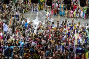 FILE - In this April 25, 2015 file photo, Native American and indigenous dancers surround head man dancer, Juaquin Hamilton, from Shawnee, Okla., following the grand entrance of the 32nd annual Gathering of Nations in Albuquerque N.M. More than 100,000 spectators, artists, and performers will be converging on Albuquerque as part of North America's largest powwow. The 33rd edition of the three-day festivities get underway Friday, April 29, 2016, at the University of New Mexico basketball arena. (AP Photo/Mark Holm, File)