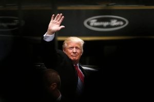 FILE - In this April 9, 2016 file photo, Republican presidential candidate Donald Trump acknowledges supporters while leaving Trump Tower in New York. Trump, Hillary Clinton and Bernie Sanders are all boasting about their New York City credentials. (AP Photo/Julio Cortez, File)