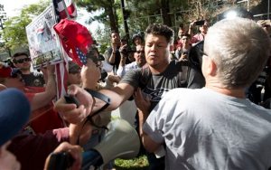 A man, center, sprays Republican presidential candidate Donald Trump supporters with pepper spray during a rally in front of the Anaheim City Hall on Tuesday, April 26, 2016, in Anaheim, Calif. (Leonard Ortiz/The Orange County Register via AP)   MAGS OUT; LOS ANGELES TIMES OUT; MANDATORY CREDIT