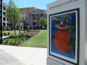 A poster for the 2016 edition of the Spoleto Festival USA is seen outside the Gaillard Center in Charleston, S.C., on May 4, 2016. The internationally known arts festival opens on May 27, 2016 and continues through June 12, 2016. "Porgy and Bess," the iconic opera set in Charleston, will be the first Spoleto production in the $142 million performing arts center that opened last fall. (AP Photo/Bruce Smith)