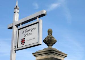 FILE - In this Jan. 7, 2016 photo a sign rests at an entrance to St. George's School in Middletown, R.I.  Alumni weekend at St. Georges School will be different this year. Itll involve discussions about what has unfolded at the elite Rhode Island boarding school since December, when school officials acknowledged dozens of students were sexually abused in the past. Many alumni have struggled with whether to attend the reunion, which runs Friday, May 6, 2016 through Sunday. (AP Photo/Steven Senne)
