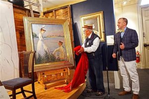 A Saturday, May 21, 2016 photo provided by the Portsmouth Historical Society shows a newly discovered and restored Edmund C. Tarbell painting being unveiled by Edmund C. Tarbell II, center, grandson of the painter, and Jeremy Fogg, guest curator and conservator, at the Discover Portsmouth visitors' center in Portsmouth, NH. The painting that was rolled up and forgotten for more than a century has been restored just in time to be included in a large retrospective of the artist's work. (Bill Moore/Portsmouth Historical Society via AP)