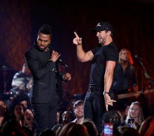 FILE - In this March 29, 2016 file photo, Jason Derulo, left, and Luke Bryan perform during a taping of CMT Crossroads in Franklin, Tenn. During an interview prior to shooting the episode, Derulo, the Talk Dirty singer, said he is really interested in making a country music record. (Photo by Donn Jones/Invision/AP, File)