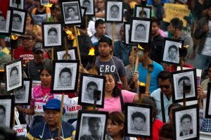 FILE - In this April 26, 2016 file photo, family members and supporters of 43 missing teachers college students carry pictures of the students as they march to demand the case not be closed and that experts' recommendations about new leads be followed, in Mexico City. Suspects are claiming Mexican police and military personnel committed systematic torture in an attempt to quickly resolve the September 2014 disappearance of 43 students who were grabbed by police and turned over to a drug gang that allegedly killed them. (AP Photo/Rebecca Blackwell, File)