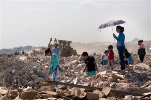 Residents comb through a field, salvaging recyclable material from post-earthquake debris, in Manta, Ecuador, Wednesday, April 20, 2016. A fresh tremor rattled Ecuador before dawn Wednesday, a magnitude-6.1 magnitude jolt that set babies crying and adults pouring into the streets, fearful of yet more damage following the 7.8-magnitude earthquake over the weekend. It was the strongest aftershock yet following Saturday's monster quake that killed more than 500 people. (AP Photo/Rodrigo Abd)