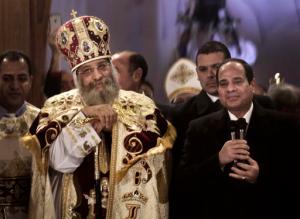 FILE - In this Tuesday, Jan. 6, 2015 file photo, Egypt's President Abdel-Fattah el-Sissi, right, visits Coptic Pope Tawadros II, center, during Christmas Eve Mass at St. Mark's Cathedral, in Cairo, Egypt. A Muslim mob ransacked and torched seven Christian homes in a province south of the Egyptian capital, Cairo, after rumors spread that a Christian man had an affair with a Muslim woman, according to a statement by the local Orthodox Coptic church. Released late Wednesday, it said that during the May 20, 2016 attack, the mother of the Christian man, who had fled the village, was publicly stripped of her clothes by the mob to humiliate her. (AP Photo/Nariman El-Mofty, File)