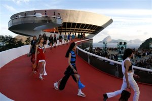Models walk down a ramp of the Contemporary Art Museum wearing creations from the Louis Vuitton Cruise 2017 collection, in Niteroi, Brazil, Saturday, May 28, 2016. The elite of the fashion world flocked to Brazil, defying an outbreak of the Zika virus, an economic meltdown and the profound political crisis afflicting the country to attend a runway show Saturday by revered French label. The iconic Sugarloaf Mountain is pictured in the background on right. (AP Photo/Leo Correa)