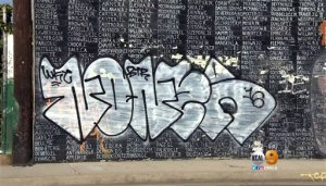 This Friday, May 27, 2016 image from video provided by KCBS-TV/KCAL-TV shows graffiti on a Vietnam War memorial in the Venice area of Los Angeles. The homespun memorial painted on a block-long wall on Pacific Avenue lists the names of American service members missing in action or unaccounted for in Southeast Asia, painted by a Vietnam veteran and dedicated in 1992. The wall has been tagged previously but the latest vandalism - within the past week - covers the bottom half of the memorial for much of its length. (KCBS-TV/KCAL-TV via AP)  TV OUT; MANDATORY CREDIT