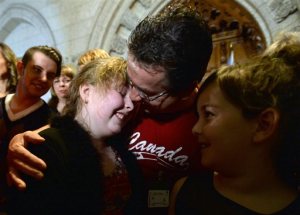Charlie Lowthian-Rickert, left, who is a transgender female, is comforted by her dad Chris Rickert and friends after speaking along side Justice Minister Jody Wilson-Raybould during an announcement in the foyer of the house of commons on Parliament Hill in Ottawa on Tuesday, May 17, 2016, regarding legislation on gender identity and gender expression. Canadian Prime Minister Justin Trudeau has put forward a bill to extend human rights protections to transgender Canadians. Wilson-Raybould said Tuesday the law is necessary to make it unequivocal that transgender persons have the right to live free from discrimination, hate propaganda and hate crimes.  (Sean Kilpatrick /The Canadian Press via AP) MANDATORY CREDIT