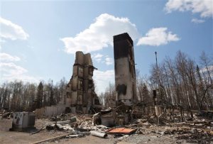 A burned building stands among charred rubble in the neighborhood of Abasand in wildfire-ravaged Fort McMurray, Alberta, on Friday, May 13, 2016. (Jason Franson /The Canadian Press via AP) MANDATORY CREDIT