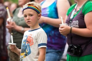 Emerson Wyzgoski, 7, of Kalamazoo, holds a candle at a candlelight vigil at Bronson Park hosted by Kalamazoo Gay Lesbian Resource Center honoring the victims of the mass shooting at Pulse nightclub in Orlando, Monday, June 13, 2016 in Kalamazoo, Mich. A gunman has killed dozens of people in a massacre at a crowded gay nightclub in Orlando, Fla. on Sunday, making it the deadliest mass shooting in modern U.S. history. (Bryan Bennett/Kalamazoo Gazette-MLive Media Group via AP) LOCAL TELEVISION OUT; LOCAL RADIO OUT; MANDATORY CREDIT
