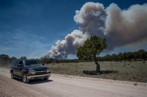 Residents of the town of Chilili along state road 337 begin to evacuate due to the Dog Head wildfire near the Manzano mountains, Wednesday, June 15, 2016, in Chilili, N.M. Authorities don't have a containment estimate yet for a wildfire burning in the Manzano Mountains southeast of Albuquerque but say good weather helped firefighters attack the fire overnight. The so-called "Dog Head Fire" in part of the Cibola National Forest east of Los Lunas started Tuesday and grew to over a square mile by Wednesday morning after its growth slowed overnight. (Roberto E. Rosales/The Albuquerque Journal via AP) MANDATORY CREDIT