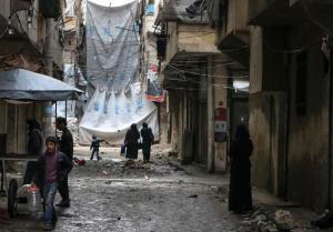 FILE - In this Thursday, Feb. 11, 2016 file photo, civilians walk through a street with large tarps are hung in between building to limit the view of regime snipers in Aleppo, Syria. Islamic State militants entered a Syrian opposition stronghold in the country's north on Saturday, clashing with rebels on the edges of the town as the extremist group built on its most significant advance near the Turkish border in two years, Syrian opposition groups and IS media said. (Alexander Kots/Komsomolskaya Pravda via AP, File)