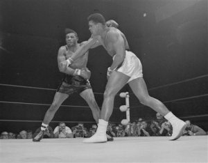 FILE - This Nov. 22, 1965 file photo shows Muhammad Ali landing a throw right to the jaw of challenger Floyd Patterson in the seventh round of their heavyweight title fight at Las Vegas. Ali's victory was perceived as cruel and unnecessary by many, even though Patterson insisted on calling Ali by his birth name and called him a loudmouth Muslim. (AP Photo/File)