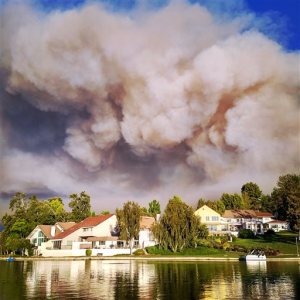 This photo provided by Matthew Dangerfield shows billowing smoke  from the Calabasas, Calif., fire as the clouds passed over the homes of Park Calabasas, Saturday, June 4, 2016. Los Angeles County fire officials now say a brushfire in the Calabasas neighborhood is threatening about 3,000 homes. Capt. Keith Mora tells KCAL-TV that's how many are near the 200-acre blaze that erupted Saturday afternoon northwest of downtown Los Angeles. He says about 200 homes and some 500 people are under mandatory evacuation but the others are strongly urged to leave the area, where flames up to 50 feet high rolled along ridgetops and torched trees right next to million-dollar homes.  (Matthew Dangerfield via AP)