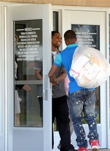 With his brother Deshon carrying his bag, Davontae Sanford, 23, smiles as he takes his first steps outside of the Bellamy Creek Correctional Facility, Wednesday, June 8, 2016, in Ionia, Mich. Sanford entered prison as a teenager in 2008 and was released Wednesday, a day after his guilty pleas to four fatal shootings were erased by a judge at the request of prosecutors who conceded the case was compromised by flawed police work. (Dave Wasinger/Lansing State Journal via AP)  NO SALES; MANDATORY CREDIT