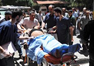 In this photo released by the Syrian official news agency SANA, shows a victim who was injured in the bombing attack in the Sayyida Zeinab suburb carried on a stretcher into a hospital in Damascus, Syria, Saturday, June 11, 2016. Two bombs went off Saturday near the Syrian capital, killing at least eight people and wounding over a dozen others in the latest attack to hit the predominantly Shiite area in recent months, state TV and an opposition activist group said. (SANA via AP)