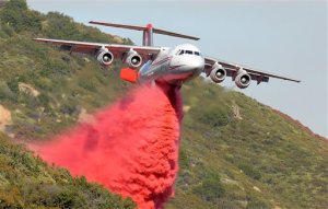 A British Aerospace BAe-146 belonging to Neptune Aviation makes a Phos-Chek drop Saturday, June 18, 2016, on wildfires in Santa Barbara County, Calif. (Mike Eliason/Santa Barbara County Fire Department via AP)