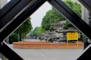 In this June 7, 2016 photo, workers walk at the China Xingyue Group compound, a factory which makes small utility vehicles and motorbikes in Zhoupu Township in Pudong district of Shanghai. Authorities have evicted hundreds of Shanghai residents and dozens of businesses to clean up the air and make way for the newest Disney theme park, which opens Thursday, June 16. (AP Photo/Paul Traynor)