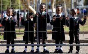 Children wearing school uniforms watch the laying of wreaths, at the Hector Pieterson Memorial in Soweto, South Africa, Thursday, June 16, 2016, for commemoration of the 40th anniversary of uprisings. South Africans are commemorating the 40th anniversary of a pivotal moment in the anti-apartheid struggle, a 1976 black student uprising in the Soweto area of Johannesburg that led to a deadly crackdown but launched a new phase of opposition to white minority rule. (AP Photo/Themba Hadebe)