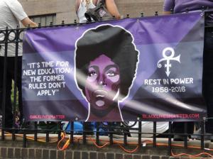 A poster bearing the likeness of the entertainer is attached to a railing at the "Prince Born Day Purple People Party" in New York, Saturday, June 4, 2016. The multi-talented singer, musician and songwriter was found dead in his Minneapolis, Minn. home on April 21. Prince Rogers Nelson would have been 58 on June 7. (AP Photo/Nekesa Mumbi Moody)