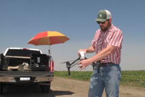 In this photo taken July 25, 2016, Danny Royer, vice president of technology at Bowles Farming Co., prepares to pilot a drone over a tomato field near Los Banos, Calif. The farm hired Royer this year to oversee drones equipped with a state-of-the-art thermal camera. The drone can scan from a bird's-eye view for cool, soggy patches where a gopher may have chewed through the buried drip irrigation line and caused a leak of water, a precious resource in drought-stricken California. On the farm's 2,400-acre tomato crop alone, this year drones could detect enough leaks to save water needed to sustain more than 550 families of four for a year. (AP Photo/Scott Smith)