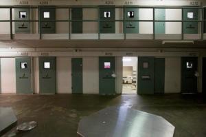 FILE - This Sept. 2, 2015 file photo shows the the door to the cell at Hampton Roads Regional Jail in Portsmouth, Va., where 24-year-old Jamycheal Mitchell was found dead Aug. 19, 2015. A year after the death of the mentally ill Virginia inmate, questions remain about how the otherwise healthy man deteriorated in plain sight of jail and health officials. In June 2016, Virginia State Police announced a criminal investigation into the matter. (Bill Tiernan/The Virginian-Pilot via AP, File)