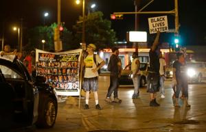 People protest and block traffic in Milwaukee, Sunday, Aug. 14, 2016.Police said one person was shot at a Milwaukee protest on Sunday evening and officers used an armored vehicle to retrieve the injured victim during a second night of unrest over the police shooting of a black man, but there was no repeat of widespread destruction of property.  (AP Photo/Jeffrey Phelps)