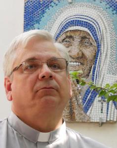 Rev. Brian Kolodiejchuk, postulator of the cause of beatification and canonization of Mother Teresa, is interviewed by the Associated Press in front of a mosaic picturing Mother Teresa, at the formation house of the priestly branch of the Missionaries of Charity on the outskirts of Rome, Friday, Aug. 18, 2016. When Pope Francis canonizes Mother Teresa on Sunday, Sept. 4, 2016, he'll be honoring a nun who won admirers around the world and a Nobel Peace Prize for her joy-filled dedication to the "poorest of the poor." (AP Photo/Giulia Sabella)
