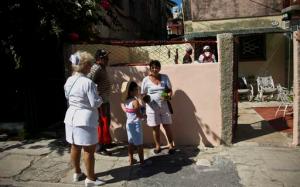 In this Aug. 26, 2016, photo, a nurse, part of the crew that is responsible for preventing the spread of the Zika virus, asks neighbors about the health situation in Havana, Cuba. Cuba is among few countries in the Western Hemisphere that has so far prevented significant spread of the disease blamed for birth defects in thousands of children. (AP Photo/Ramon Espinosa)