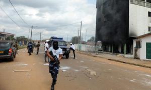 Gabonese Police stand guards on a barricade following an election protest in Libreville, Gabon, Thursday Sept. 1, 2016. Gabon's newly re-elected president sought to assert authority Thursday as the presidential guard attacked the opposition candidate's party headquarters overnight, killing at least one person and injuring more than a dozen amid fiery protests that have seen hundreds detained and the internet blocked.( AP Photo/Joel Bouopda)