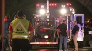 Bomb squad personnel stand around the scene of an explosion near the train station early Monday, Sept 19, 2016, in Elizabeth, N.J. A suspicious device found Sunday night in a trash can near a New Jersey train station exploded early Monday as a bomb squad robot attempted to disarm it. (Jessica Remo/NJ Advance Media via AP)