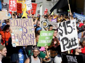 FILE - In this April 14, 2016, file photo, union organizers, students, and supporters for a $15 an hour wage march through the Oakland section Pittsburgh. Modest income growth for most Americans, strikes by fast-food workers, and the rapid growth of low-paying jobs at the same time middle-income work shrinks have combined to make the minimum wage a top economic issue for the 2016 campaign. (AP Photo/Keith Srakocic, File)