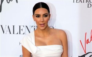 FILE - In this Sunday, May 22, 2016 file photo, Kim Kardashian poses for photographers as she arrives for the premiere of Verdis La Traviata at the Rome Opera House, in Rome. Serial celebrity prankster Vitalii Sediuk has struck again, this time at Paris Fashion Week, targeting Kim Kardashians derriere as she was entering the L'Avenue restaurant. Kardashians makeup artist caught the Wednesday, Sept. 28, 2016 incident in a video that he posted to his Instagram account. It shows the reality television star negotiating her way through a crowd of paparazzi past her black car, as Sediuk, a former Ukrainian television reporter, swoops in and seems to attempt to kiss Kardashians posterior. (AP Photo/Andrew Medichini, file)