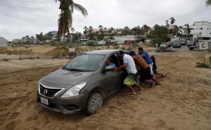 People help a tourist move his car after it became stuck in the sand, after the passing of Hurricane Newton in Cabo San Lucas, Mexico, Tuesday, Sept. 6, 2016. Hurricane Newton shattered windows, downed trees and knocked out power in parts of the twin resorts of Los Cabos on Tuesday, but residents were spared the kind of extensive damage seen two years ago when they were walloped by a monster storm. (AP Photo/Eduardo Verdugo)