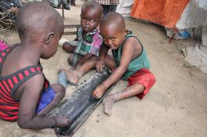 Children play on the ground outside their makeshift home in a refugee camp in Mogadishu, Somalia, Tuesday,Sept,20, 2016. A new U.N. report says five million people in Somalia are not getting enough food. That's more than 40 percent of the population of this chaotic Horn of Africa country. The report released Tuesday says the number of people who are food insecure has increased by 300,000 since February. The report says more than 300,000 children under 5 are acutely malnourished. (AP Photo/Farah Abdi Warsameh)