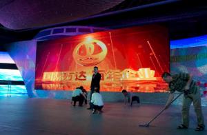 FILE - In this June 19, 2013 file photo, Chinese workers prepare the stage ahead of a ceremony for Dalian Wanda Group at a hotel in Beijing, China. China's Dalian Wanda Group and Sony Pictures Entertainment Motion Picture Group have formed a partnership to cooperate on multiple big-budget movies, marking another step into the global film industry by the Chinese conglomerate. Chinese characters on screen reads "International Wanda, Century Enterprise." (AP Photo/Ng Han Guan, File)