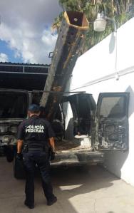 In this Sept. 17, 2016 photo released by Mexico Federal Police, an officer stands next to a van outfitted with a 10-foot (3-meter) air cannon in Agua Prieta, Mexico, along the border with Douglas, Arizona. According to federal police, it was used to shoot projectiles into the U.S. and the van was reported stolen from the city of Hermosillo in the Mexican state of Sonora over the summer. a U.S. Border Patrol spokesman said that the most common common use for this sort of device is lobbying marijuana packages over the border fence. (AP Photo/Policia Federal Preventiva)