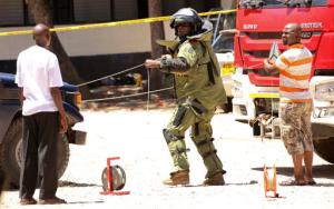 A member of a bomb disposal team prepares the scene before checking the bodies of three women who were shot dead by police, outside the central police station in the coastal city of Mombasa, Kenya Sunday, Sept. 11, 2016. The three women were killed by police after they attacked the police station using petrol bombs and knives, a police official said Sunday. (AP Photo)