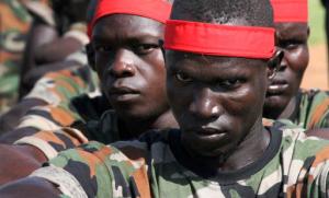 FILE - In this Monday, May 16, 2016 file photo, a group of government soldiers wait in line during a military parade celebrating the national army in Juba, South Sudan. A new report Monday, Sept. 12, 2016 by a U.S.-based watchdog group accuses South Sudan's rival leaders of amassing wealth abroad amid a conflict in which tens of thousands have been killed. (AP Photo/Justin Lynch, File)