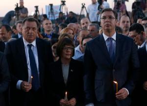 Serbian Prime Minister Aleksandar Vucic, right, Milorad Dodik President of the Republika of Srpska entity of Bosnia and Herzegovina, left, and Serbian Parliament President Maja Gojkovic hold candles during a memorial service for the victims of the Croatian "Storm" offensive, to mark the 21th anniversary in the village of Busije, some 25 kilometers (15 miles) west of Belgrade, Serbia, Thursday, Aug. 4, 2016. Croatia is marking its military operation with victory celebrations, while Serbia considers the "Storm" offensive a war crime that resulted in the exodus of most Serbs living in Croatia. (AP Photo/Darko Vojinovic)