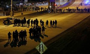 Police confront protesters blocking I-277 during demonstrations following Tuesday's police shooting of Keith Lamont Scott in Charlotte, N.C., Thursday, Sept. 22, 2016. (AP Photo/Gerry Broome)