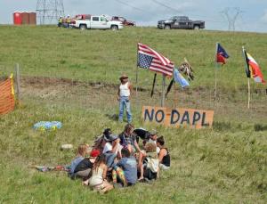 Bill Left Hand, of McLaughlin, South Dakota, stands next to a sign at the site of a protest Friday, Aug. 12, 2016, against construction of the Dakota Access Pipeline that will cross the Missouri River in Morton County. The pipeline would start in North Dakota and pass through South Dakota and Iowa before ending in Illinois. Construction of the pipeline began this week just north of the Standing Rock Sioux reservation. Nearly 200 people came from across the country to join in the protest. (Tom Stromme/The Bismarck Tribune via AP)