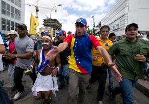 FILE - In this Sept 1, 2016 file photo, Venezuelan opposition leader Henrique Capriles takes part in the "taking of Caracas" march in Caracas, Venezuela. Capriles says he was harassed in a Margarita island airport for four hours by armed and hooded government supporters. The tense standoff ended after midnight Wednesday, Sept. 7,  when the supporters withdrew from an area close to baggage claim where they awaited Capriles.   (AP Photo/Ariana Cubillos, File)
