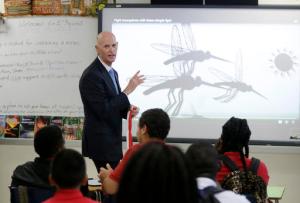 Florida Gov. Rick Scott talks with students who are studying the Zika virus, while visiting a classroom on the first day of school at the Jose de Diego Middle School, Monday, Aug. 22, 2016, in the Wynwood neighborhood of Miami. Mosquito-borne Zika cases have been found in an area of Wynwood, and in a section of Miami Beach. The CDC has issued an advisory for pregnant women to avoid travel to these two zones. (AP Photo/Lynne Sladky)