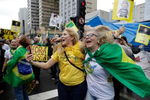 People celebrate the impeachment of Brazil's President Dilma Rousseff in Sao Paulo, Brazil, Wednesday, Aug. 31, 2016. Brazil's Senate on Wednesday voted to permanently remove Rousseff from office 61-20, more than the 54 votes they needed. (AP Photo/Andre Penner)
